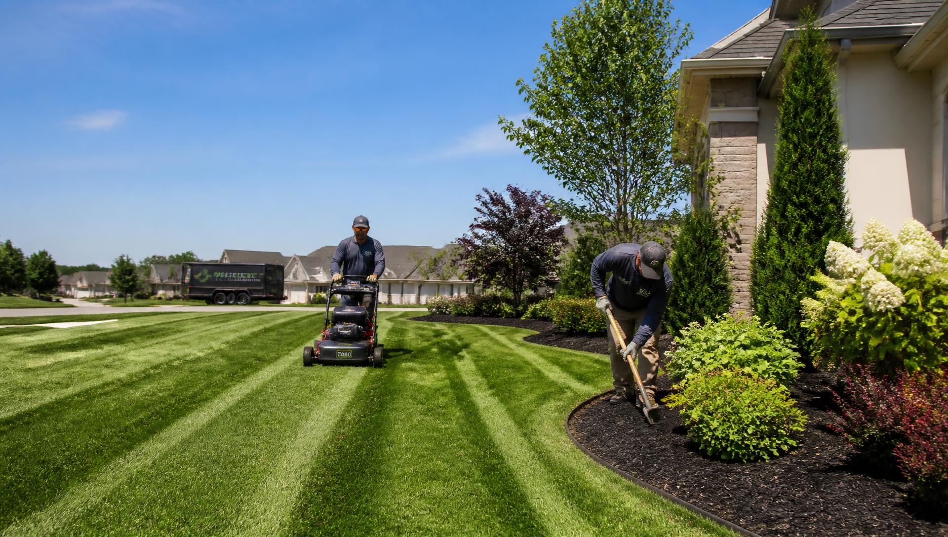 Landscaping crew mowing a striped lawn