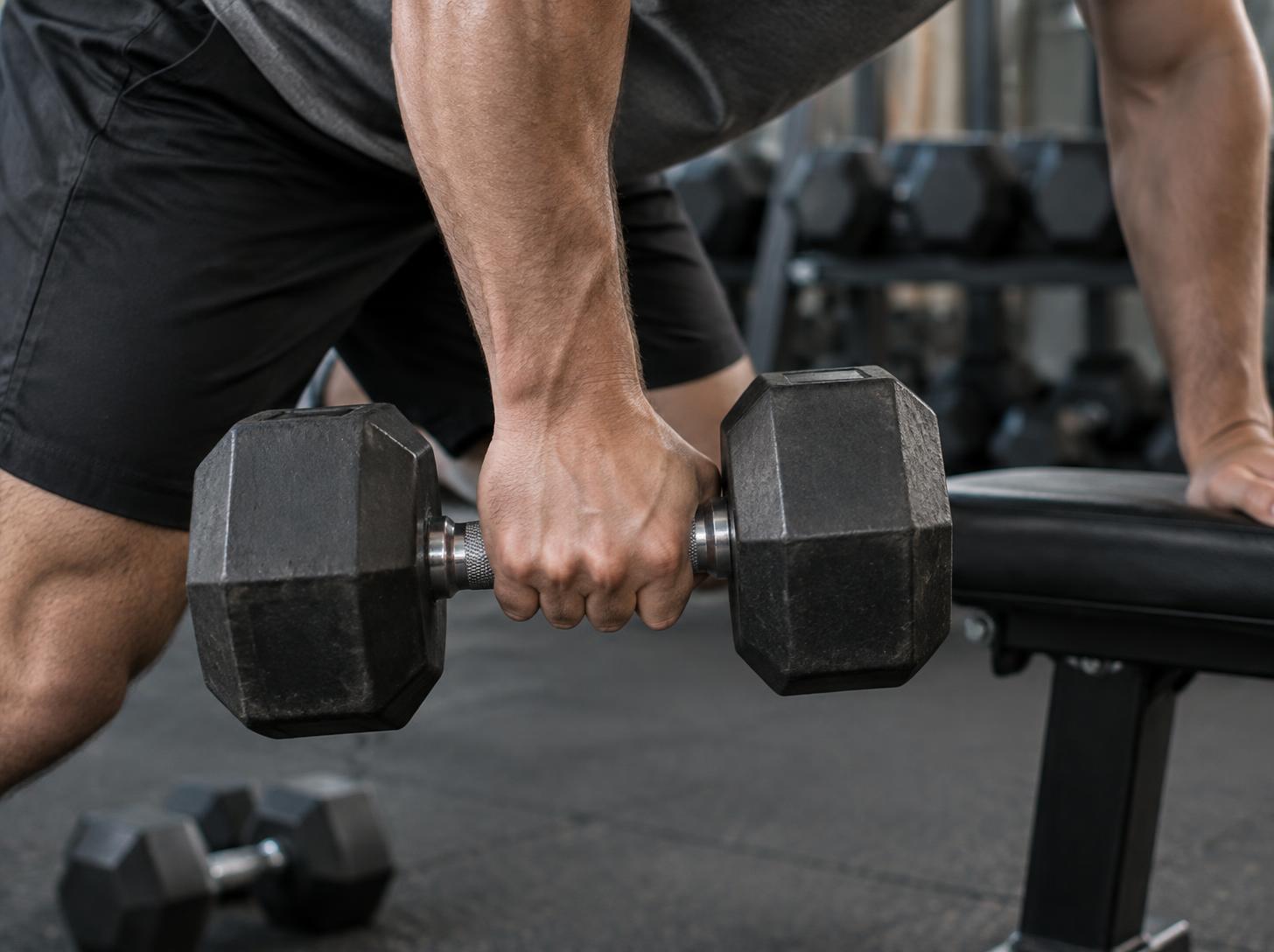 Close-up of a natural hand grip on a hex dumbbell during a controlled row