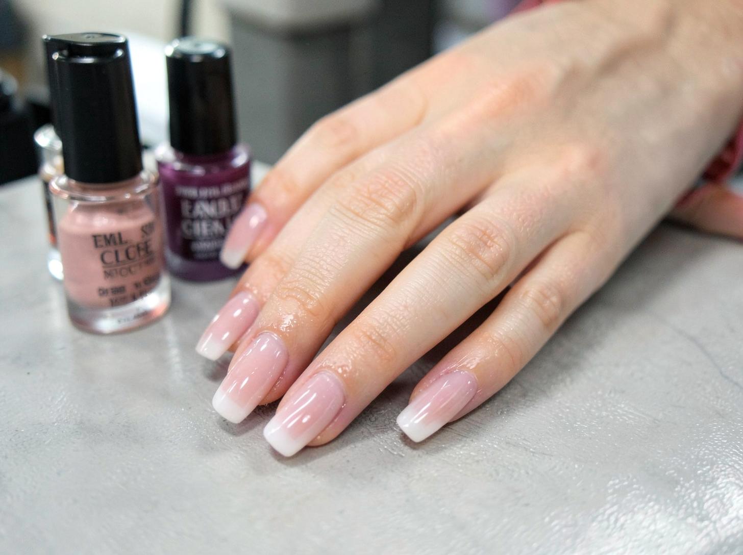 Close-up of freshly finished glossy manicured nails on a salon table
