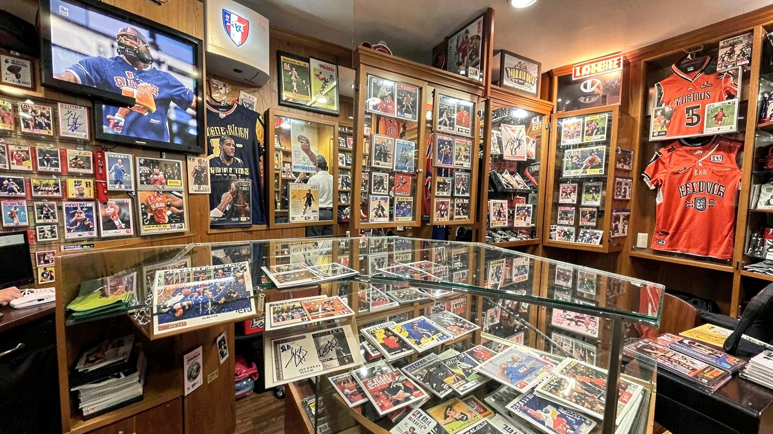 Sports card shop interior with glass display cases and signed jerseys